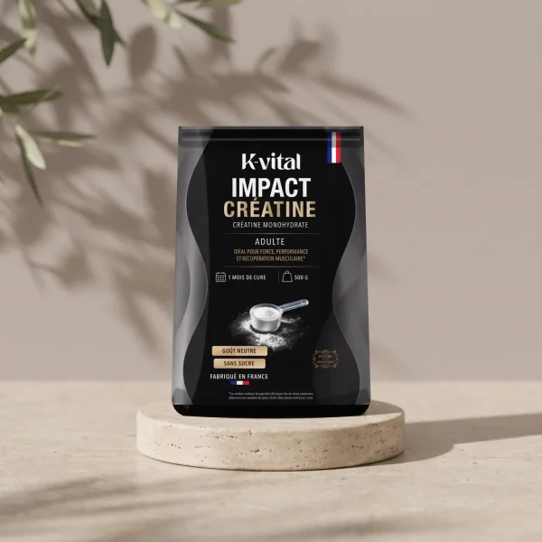 Sachet Impact Créatine K-Vital sur un socle de travertin, mur gris taupe